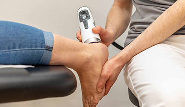 Fuß wird mit Stoßwellentherapie behandelt